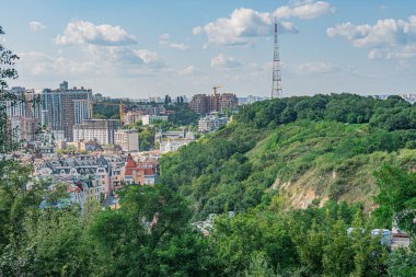 Ukrayna 'nın başkenti Kyiv' in panoramik manzarası, kentsel gelişim ve yeşillik karışımının yer aldığı şehir manzarası, hem daha eski hem de daha yeni yapısına sahip Lush Kyiv, Ukrayna - 11 Ağustos 2025