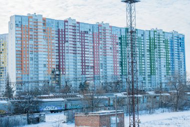 Her katta Ukrayna, Kyiv 'de çok katlı, canlı bir konut binası, geçen tren raylarının bitişiğinde gökyüzü bulutlu, haberleşmeli Kyiv, Ukrayna - 17 Şubat 2026