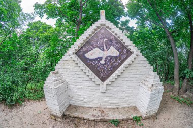 Lekeli orman ortamında sivri çatılı taş tuğla kulübe, Ukrayna Dekoratif desenleri, boyalı cam, doğal çevre, renkli karşıtlık, sessiz tonlar, sükunet, Kyiv, Ukrayna - 4 Ağustos 2025