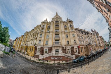 Tarihi bina harmanı, Kyiv caddesi manzarası, kaldırım taşı yolu, kemerler, sütunlar, karmaşık desenler, eşit aralıklı pencereler, zıt çerçeveler, Kyiv kavisi, Ukrayna - 6 Ağustos 2025