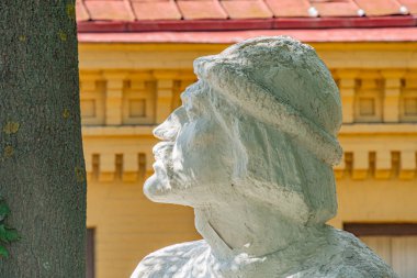 Geniş, bej renkli, geleneksel giyimli bir adam heykeli, halka açık bir yer, taş veya beton malzeme, uzun saç, sarı bina zemin, doğal Kyiv, Ukrayna - 11 Ağustos 2025