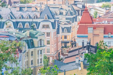 Kentsel Kyiv şehir manzarası, renkli cepheli ve çatıları olan yoğun binalar, doğal yumuşak ışıklandırma, dikey vurgu, yeşillik kontrastı, fotoğraf gerçekçi quali Kyiv, Ukrayna - 11 Ağustos 2025