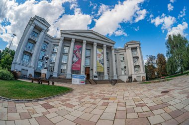 Dikdörtgen taş mozaik, klasik bina, sütunlar, peçeler, büyük pencereler, afişler, kültürel etkinlikler veya sergi, açık mavi gökyüzü, dağınık c Kyiv, Ukrayna - 18 Ağustos 2025
