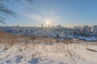 Kiev, Ukrayna 'da kış manzarası seyrek bitki örtüsü, uzak şehir manzarası, açık mavi gökyüzü, yumuşak aydınlatma, mimari çeşitlilik, aktivite veya insan yok