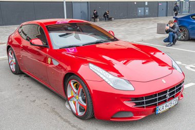 İtalyan markalı kırmızı bir spor araba, pist özellikleri aerodinamik tasarımı, LED farlar, alaşım tekerlekleri ve hava girişleri üzerine park edilmiş Ukrayna 'nın 10-12-2024 sayılı kamu konumu Kyiv' de görüldü.