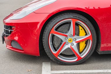 Pürüzsüz dizaynını ve havalandırmalı disk frenlerini sergileyen kırmızı bir spor arabanın yakın plan görüntüsü bulutlu hava koşulları altında, metin ya da eylem olmadan gündüz vakti Kyiv, Ukrayna 10-12-2024