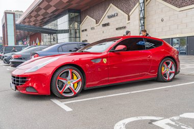 Kırmızı bir Ferrari spor arabası şehir caddesinde, Avrupa kentsel ya da ticari geçmişe sahip olabilir. Aracın kendine özgü stili ve yüksek performanslı sutyeni Kyiv, Ukrayna 10-12-2024