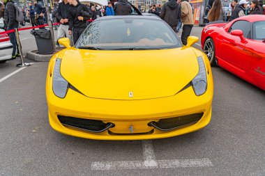 Parlak sarı bir Lamborghini, muhtemelen bir Giallo, bir araba fuarında ya da sergide park halinde. Arabanın kendine özgü tasarım unsurları var, çoklu Kyiv, Ukrayna 10-12-2024