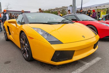 Görüntü sarı egzotik bir spor arabayı resmediyor, muhtemelen lüks bir araç etkinliğinde park edilmiş. Odak noktası araba rengi ve ayrıntıları, Kyiv, Ukrayna 10-12-2024