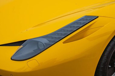 Modern aerodinamik tasarıma sahip sarı, yüksek performanslı spor bir arabanın yakın plan görüntüsü, parlak ışık koşullarında, muhtemelen asfalt bir yolda veya park alanında çekilmiş The ve Kyiv, Ukrayna 10-12-2024