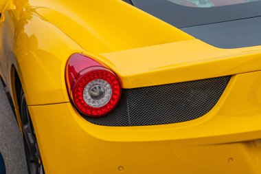 Aerodinamik tasarımı olan sarı bir spor araba, büyük hava girişleri, çok dilli tekerlekler, arka spoiler, ve özel stop lambası bir piste park edilmiş egzoz borusu Kyiv, Ukrayna 10-12-2024