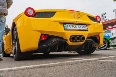 Açık kapıları olan parlak sarı bir Ferrari spor arabası, arka planı bulanık, plakası görünür ama okunamaz bir şekilde Ukrayna, Kyiv, 10-12-2024 'te çekilmiş.