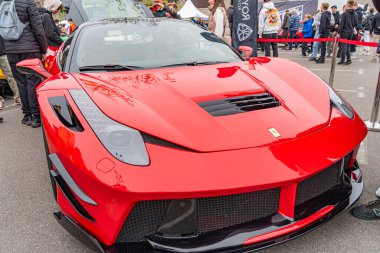 Kırmızı, yüksek performanslı, aerodinamik hatlara sahip bir spor araba bir pistte park halinde görünür bir markası yok, ama lüks ve yarış arabalarına benziyor Kyiv, Ukrayna 10-12-2024