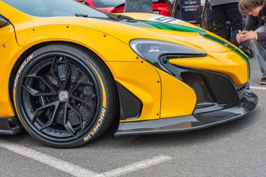 Sarı bir yarış arabasının, muhtemelen bir Formula 1 aracının, bir yarış etkinliği veya pit stop alanına park edilmiş, aerodinamik bir tasarıma sahip, Kyiv ile siyah tekerlekler, Ukrayna 10-12-2024