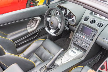 Görüntü bir spor arabanın çarpık iç görünüşünü gösteriyor, muhtemelen deri koltuklu bir Porsche sarı aksanlı gösterge paneli takometreye ve hız göstergesine sahip, alo Kyiv, Ukrayna 10-12-2024