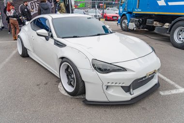 Modifiye edilmiş beyaz spor bir arabanın yakın plan çekimi bir otomotiv etkinliğinde ya da toplanırken özel aerodinamik parçalı geniş gövdeli bir araç, multi-s Kyiv, Ukrayna 10-12-2024