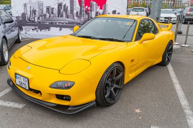 Hafif açılı konumlanmış sarı bir spor araba, siyah aksanlı ve aerodinamik özellikli parlak bir tasarım sergiliyor. Görüntü yüksek performanslı yetenekler gösteriyor, p Kyiv, Ukrayna 10-12-2024