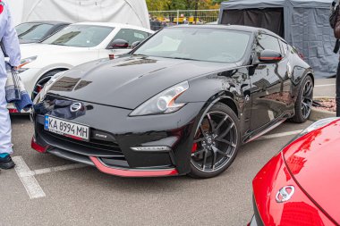 Ukrayna 'nın başkenti Kyiv' de 10-12-2024 tarihli bir otomobil fuarı veya sergisinin odak noktası siyah Nissan GT-R olan çok sayıda spor arabanın görüntüsü