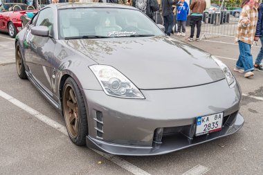 Düşük profilli lastik tasarımı ve yarış estetiğine sahip gümüş renkli, modifiye edilmiş bir Japon spor arabası bir etkinlikte veya toplanırken görüntüde Ukrayna, Kyiv, Ukrayna 10-12-2024