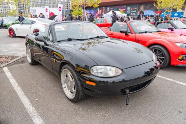 Siyah bir spor arabanın iki farklı perspektifini gösteren bölünmüş ekran görüntüsü - ön sürücü tarafı ve arka yolcu tarafı - her iki fotoğraf da Ukrayna 'nın 10-12-2024 numaralı tarma Kyiv üzerinde park edilmiş aracı gösteriyor.