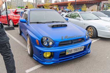 Modifiye edilmiş bir Honda Civic EK9 varyantı olan mavi bir spor araba kapalı bir otoparkta park edilmiş durumda. Arka planda Kyiv, Ukrayna 10-12-2024