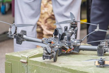Görüntü, zeytin yeşil metal bir kutuda kuadkopter bir dron tasvir ediyor İHA 'nın dört pervanesi, elektronik parçaları, muhtemel uçuş kontrol sistemleri, sensörleri ve güç kaynağı Kyiv, Ukrayna 10-12-2024