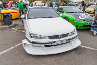 Açık hava araba fuarında modifiye edilmiş beyaz Honda Civic ve diğer araçlar The Civic 'in arka kanat spoiler, yan etek ve vücut kiti gibi yarış modifikasyonları ile Kyiv, Ukrayna 10-12-2024