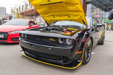 Siyah sarı spor bir arabanın yakın görüntüsü, kaput açık motor bileşenleri geniş hava girişleri ve ön bölme ayarı ile agresif stil, olası Kyiv, Ukrayna 10-12-2024