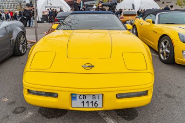 CB 116 Kyiv, Ukrayna 10-12-2024 plakalı canlı sarı renkli, şık bir spor araba.