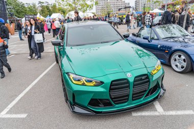 Gösterişli yeşil bir spor araba halka açık bir etkinlikte ya da toplanmada, aerodinamik özellikler ve çok dilli alaşımlı tekerlekler sergiliyor. Gündüz Kyiv, Ukrayna 10-12-2024 boyunca gökyüzü parçalı bulutludur.