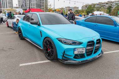 Özelleştirilmiş mavi bir spor araba açık hava etkinliklerinde park edilir, geniş gövdeli çamurluklar, büyük spoiler ve modifiye edilmiş ızgara gibi pazar sonrası parçaları sergilenir. Araç 10-12-2024 Ukrayna, Kyiv, Tinte 'e sahiptir.