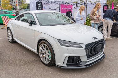 Bir spor araba, muhtemelen performans modifikasyonları olan bir Audi modeli, bir kamu etkinliğinde sergilenmektedir aerodinamik özellikleri, büyük tekerlekleri ve LED farları vardır The im Kyiv, Ukrayna 10-12-2024