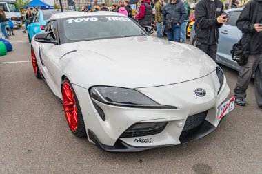 Daha büyük kırmızı jantları, özel aerodinamik kaportası ve TOYOTA da dahil olmak üzere modifiye edilmiş beyaz bir spor araba, Ukrayna 'nın başkenti Kyiv' de 10-12-2024 yıllarında halka açık bir otoparkta resmedildi.