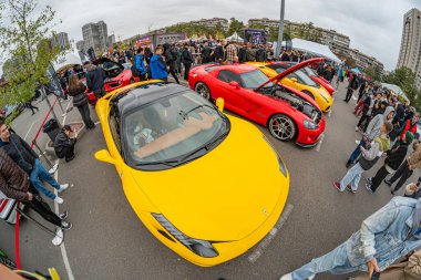 Açık hava otomotiv fuarı veya etkinliği, çok sayıda sarı ve kırmızı spor araba, büyük bir kalabalık, kamusal alan otoparkı, gizli fotoğraf Kyiv, Ukrayna 10-12-2024