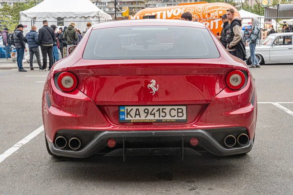 Bir etkinlik ya da toplanma sırasında şehir caddesinde park etmiş bir Ferrari 'nin gizli bir fotoğrafı. Spor arabanın kendine özgü yuvarlak stop lambaları ve oval bir amblemi var. Kyiv, Ukrayna 10-12-2024