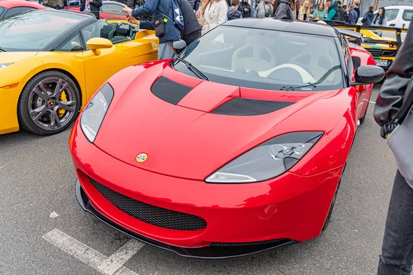 Kırmızı bir spor araba bir otomobil fuarında sergileniyor, aerodinamik tasarım sergileniyor, güçlü motor hava girişi tarafından ima ediliyor, hız performansı için çok dilli tekerlekler, I Kyiv, Ukrayna 10-12-2024