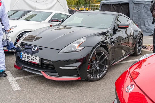 Ukrayna 'nın başkenti Kyiv' de 10-12-2024 tarihli bir otomobil fuarı veya sergisinin odak noktası siyah Nissan GT-R olan çok sayıda spor arabanın görüntüsü