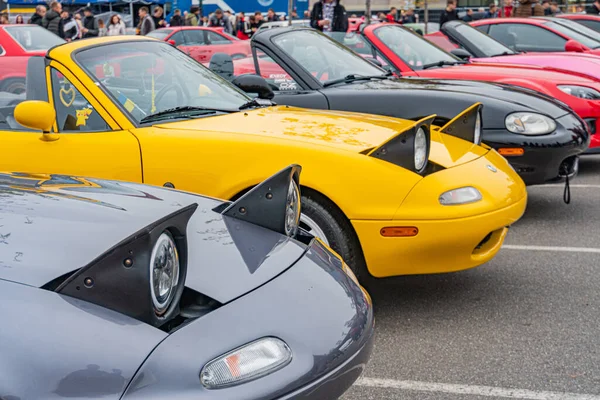 Yüksek performanslı spor arabaların büyük çoğunluğu açık havada park halindedir. Bir aracın kaputu açık, yarış motoru açık. Bazılarının kanat spikerleri Kyiv, Ukrayna 10-12-2024