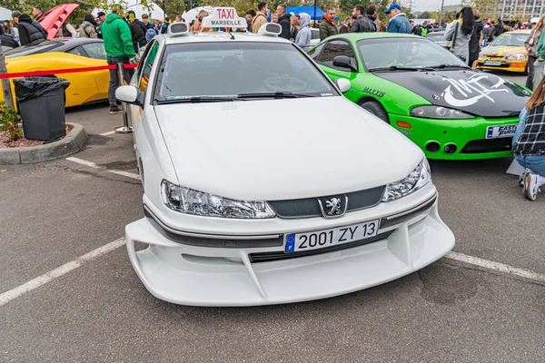 Açık hava araba fuarında modifiye edilmiş beyaz Honda Civic ve diğer araçlar The Civic 'in arka kanat spoiler, yan etek ve vücut kiti gibi yarış modifikasyonları ile Kyiv, Ukrayna 10-12-2024