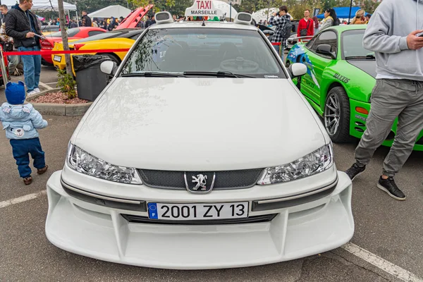 Açık hava otomobil fuarında çekilen bir fotoğraf 2001 ZY 13 'ün benzersiz tasarım unsurları diğer renkli arabalar, günlük kıyafetler içindeki insanlar ve tipik aktivite Kyiv, Ukrayna 10-12-2024