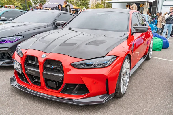 Olası bir araba fuarında asfalta park edilmiş kişiselleştirilmiş bir BMW aracın siyah aerodinamik parçaları, piyasa tekerleri, LED ışıkları ve performans güncellemeleri Ukrayna 10-12-2024