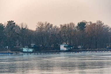 St. Sophia Katedrali 'nin yakın plan görüntüsü, Kyiv Donmuş rıhtım sahnesi kıyı boyunca basit ahşap yapılar, arka planda çıplak ağaçlar, sessiz toprak tonu co Kyiv, Ukrayna - 13 Şubat 2025
