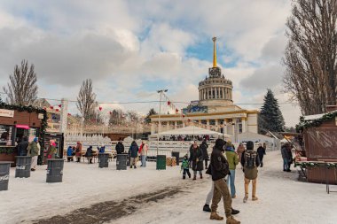 Kyiv Neoklasik mimarideki VDNH sergi merkezinde kış şenlikleri, pazar tezgahları, karlı yayalar, sıcak kıyafetler, Noel süslemeleri, Christma Kyiv, Ukrayna - 15 Şubat 2025