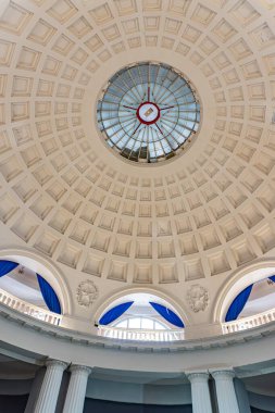 Geniş, dairesel tavan penceresi karmaşık tavan detaylarıyla duvarlarda simetrik olarak sıralanmış mavi ve beyaz pencereler, nötr Kyiv, Ukrayna - 15 Şubat 2025