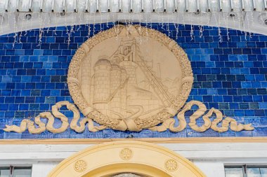 Kyiv 'deki VDNH binasında birbirine dolanmış yılanların duvar resmi, eş merkezli daireler ve stilize edilmiş yapraklar zengin mavi ve yeşil palet, dinamik beyaz şelale l Kyiv, Ukrayna - 15 Şubat 2025