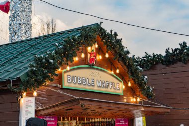 Kyiv 'deki VDNH sergi merkezi, halk şenliği, sıcak şarap satışı, Bubble Waffle adlı gıda tezgahı, Noel süslemeleri, kahverengi, yeşil, beyaz, kırmızı acc Kyiv, Ukrayna - 15 Şubat 2025