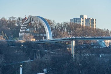 Kiev 'in havadan görünüşü, Dinyeper Nehri' nin üzerinde kavis çizmiş, şehrin iki bölümünü birleştiren belirgin beyaz çelik bir köprü içeriyor.