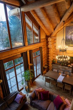 11.28.2025 - Bad Kirchheim, Avusturya: Büyük pencereli ve Avustralya Alplerinde sıcak ahşap kaplamalı konforlu kabin oturma odası .