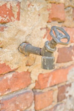 Duvardaki eski paslı musluk.