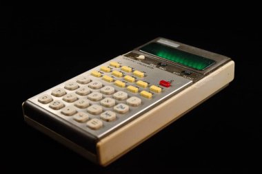 1970 'lerden kalma yeşil bir VFD ekranlı retro elektronik hesap makinesinin yakın plan görüntüsü. Ticari kullanım için genel model.